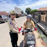 Personel Polres Labuhanbatu Selatan Bagikan Bendera Merah Putih Sambut Hari Kemerdekaan